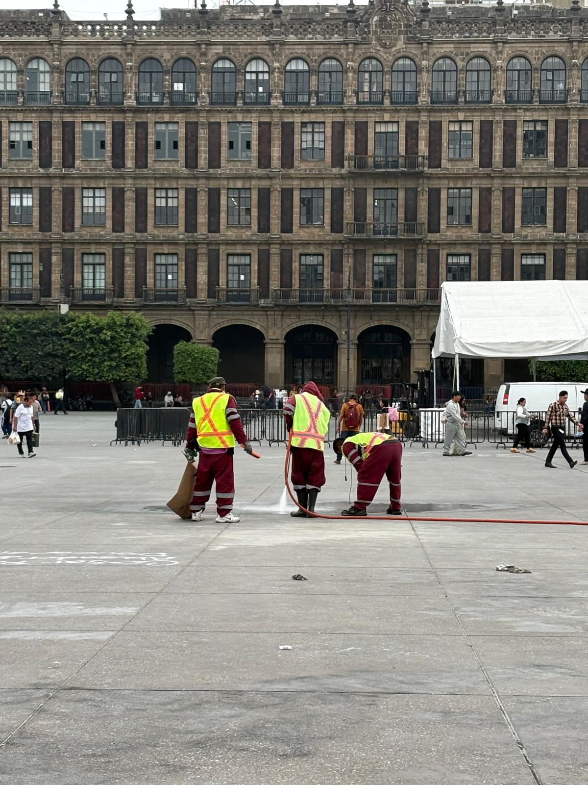 Picture of 3 persons cleaning the graffiti off the floor.