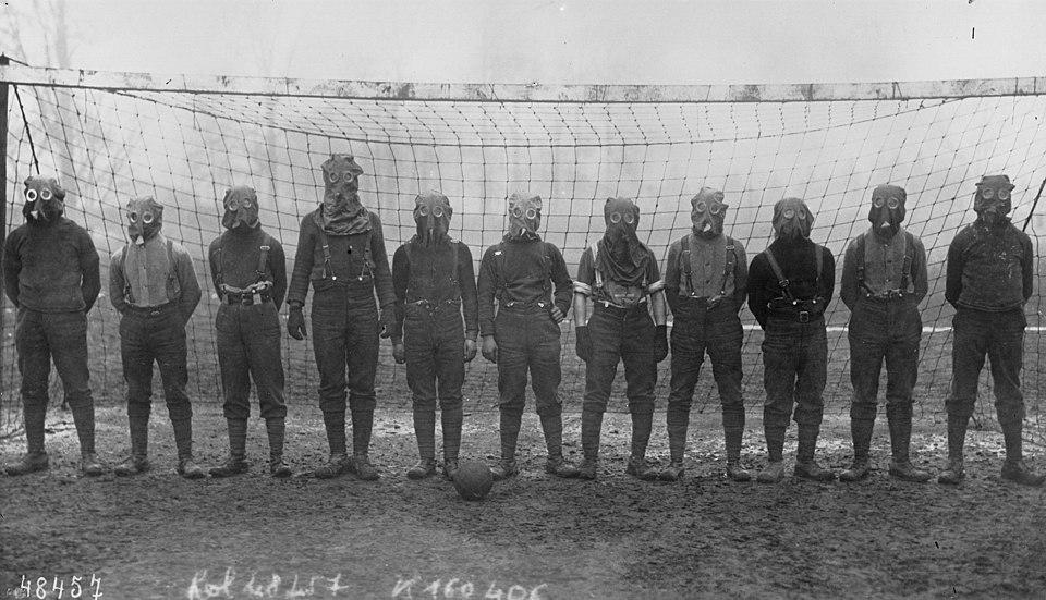 Football Team of British Soldiers with Gas Masks by Agence Rol is licensed under Public Domain.