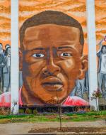 Freddie Gray's face is in the middle and protesters to the right and left 