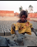 A single south Asian girl working with dust and cement blocks. Her dress is messy and loose fitting. She has dust and grime all over her body.