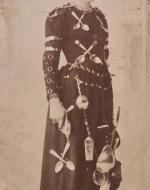 Photograph of young woman wearing a dress covered with cutlery