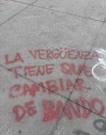 graffiti on ground: La vergüenza tiene que cambiar de bando (shame has to change side)