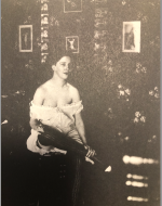 Bellocq, E. J. Storyville Photo, Sitting woman with erotic photos behind her. 1912.