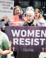 Protest against laws in favor of separating families at the border. Protester draws upon womanhood, seen to be holding a banner stating women resist these laws. 