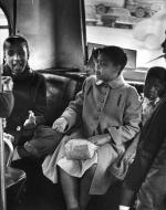 Group of colored children, crowded on a school bus.