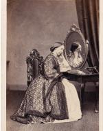 A woman dressed in front of a mirror.