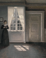 A woman is reading a book next to a window where the sunlight passes through showing the window's shadow.
