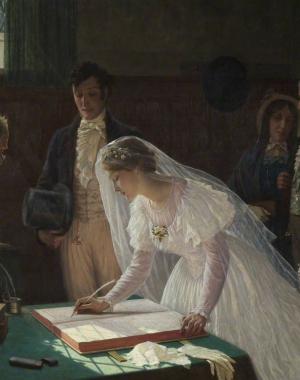 A bride signs the wedding register in front of her husband and the officiant; friends and family in the background.