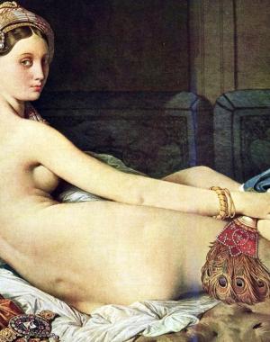 Woman lays on bed surrounded staring at viewer. 