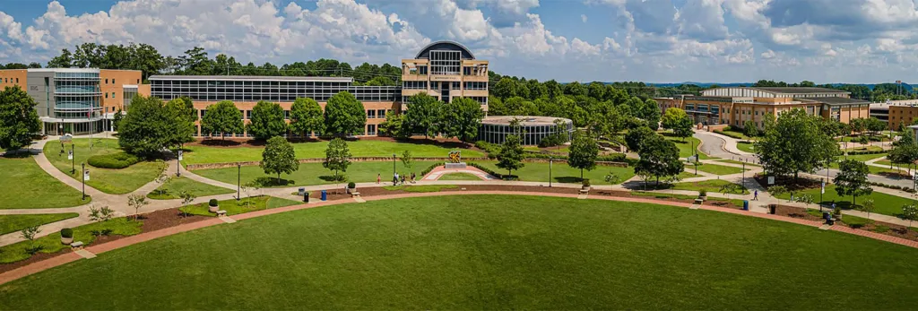 Campus of Kennesaw State University. Green trees and stone buildings.